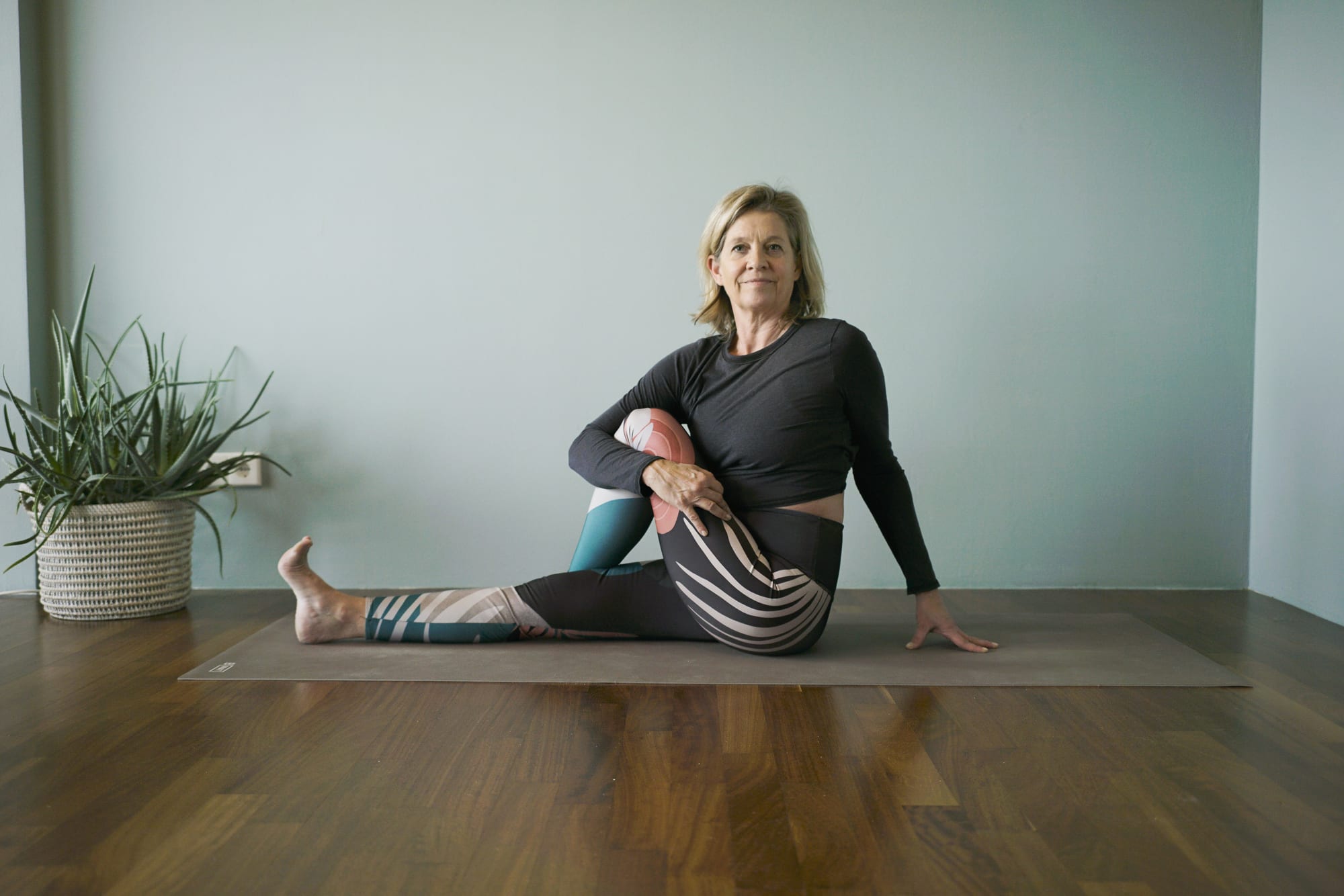 Yogalehrerin im sitzenden Drehsitz auf der Matte